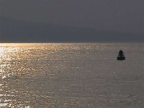 Buoy on sunlit sea