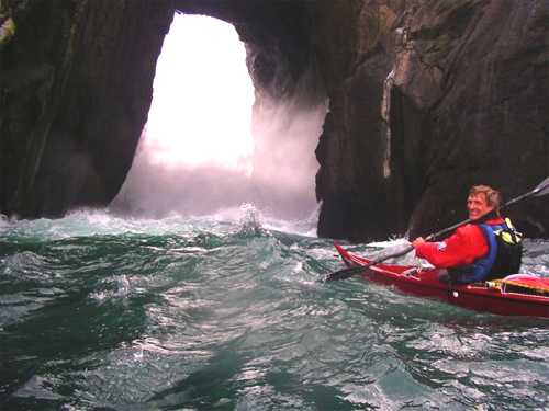 Large wave entering cliff arch