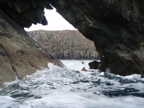 Big wave entering cliff arch